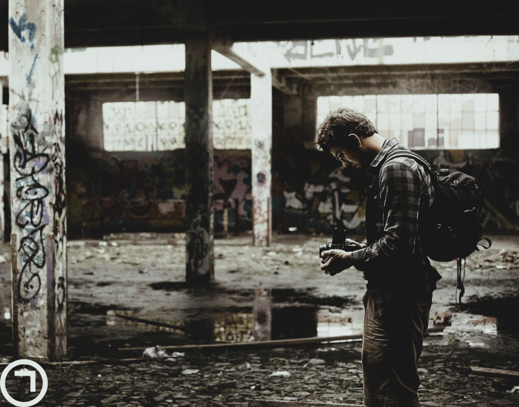 man exploring abandoned building with camera