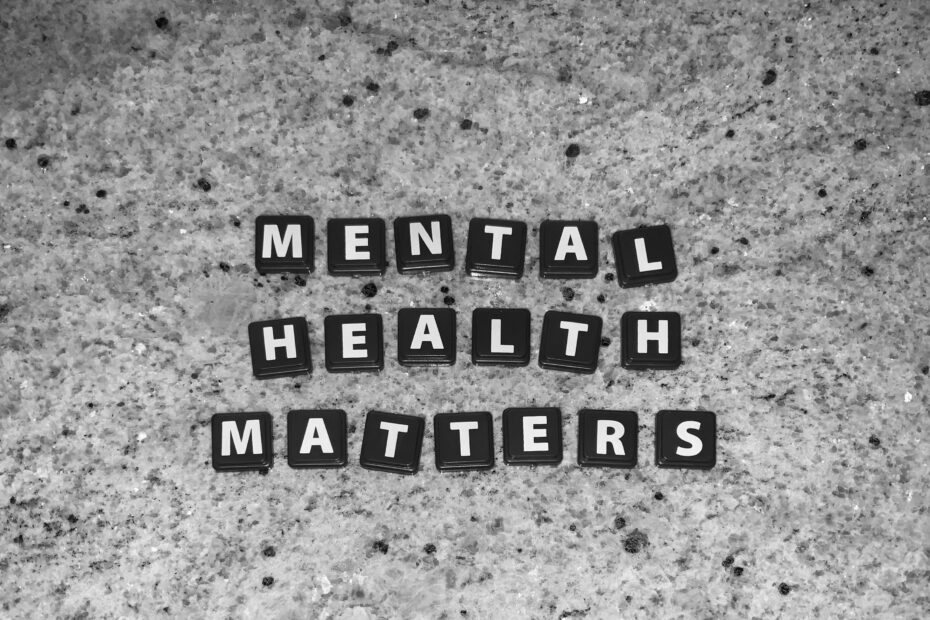 Black tiles spelling “Mental Health Matters” arranged on a textured grey surface.
