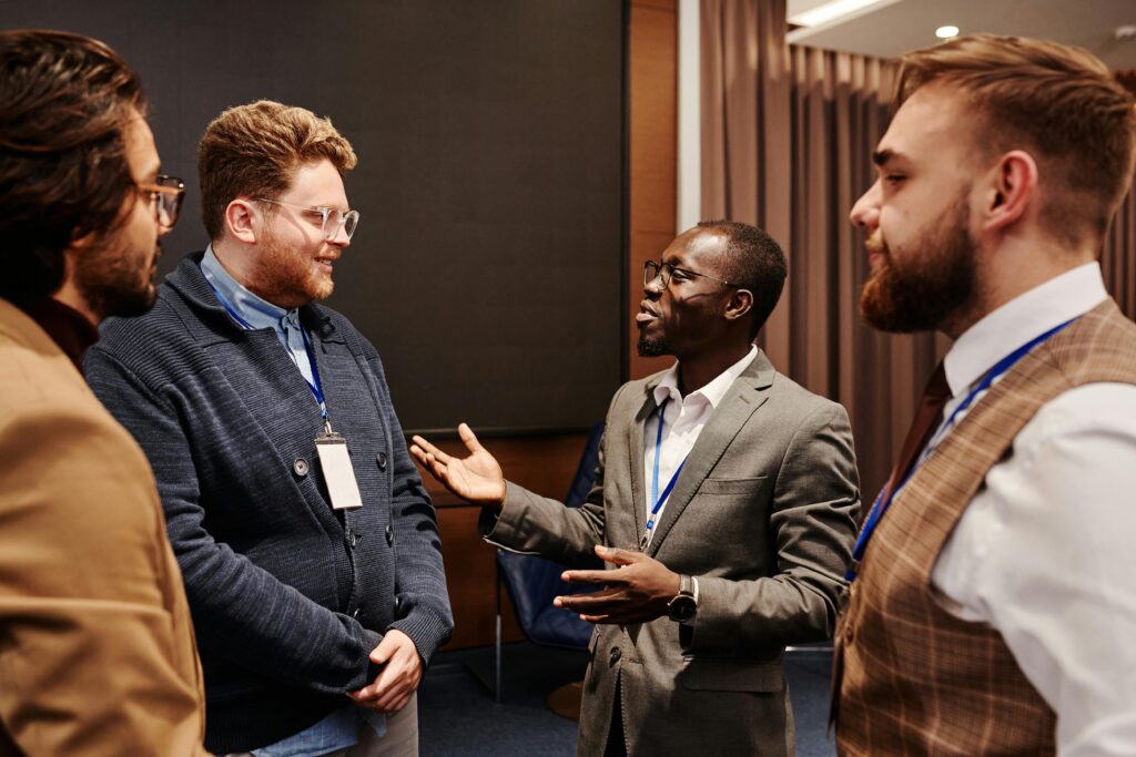 Group of diverse business professionals engaged in a lively discussion indoors.
